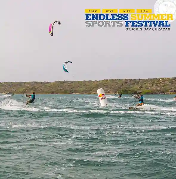Kiteboarders riding flat waters at St. Joris Bay, Curaçao, during kiteboarding lessons festival